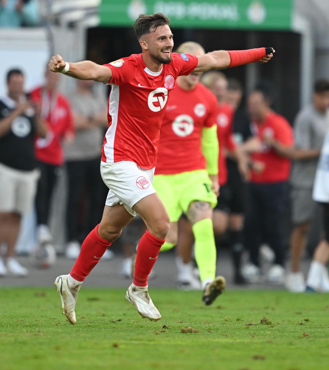 DFB-Pokal 2024/25, Kickers Offenbach - 1. FC Magdeburg, 1. Runde: Offenbachs Torschütze Valdrin Mustafa und seine Mitspieler jubeln nach dem Sieg. 