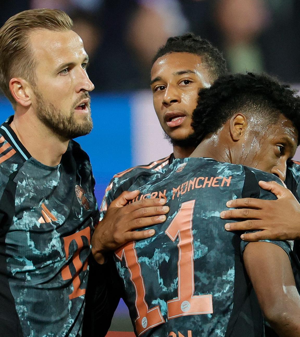 Michael Olise feiert sein Tor zum 5:0 mit Kingsley Coman und Harry Kane (links) im Bundesliga-Spiel Holstein Kiel - Bayern München am 14.0.2024.