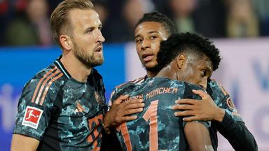Michael Olise feiert sein Tor zum 5:0 mit Kingsley Coman und Harry Kane (links) im Bundesliga-Spiel Holstein Kiel - Bayern München am 14.0.2024.