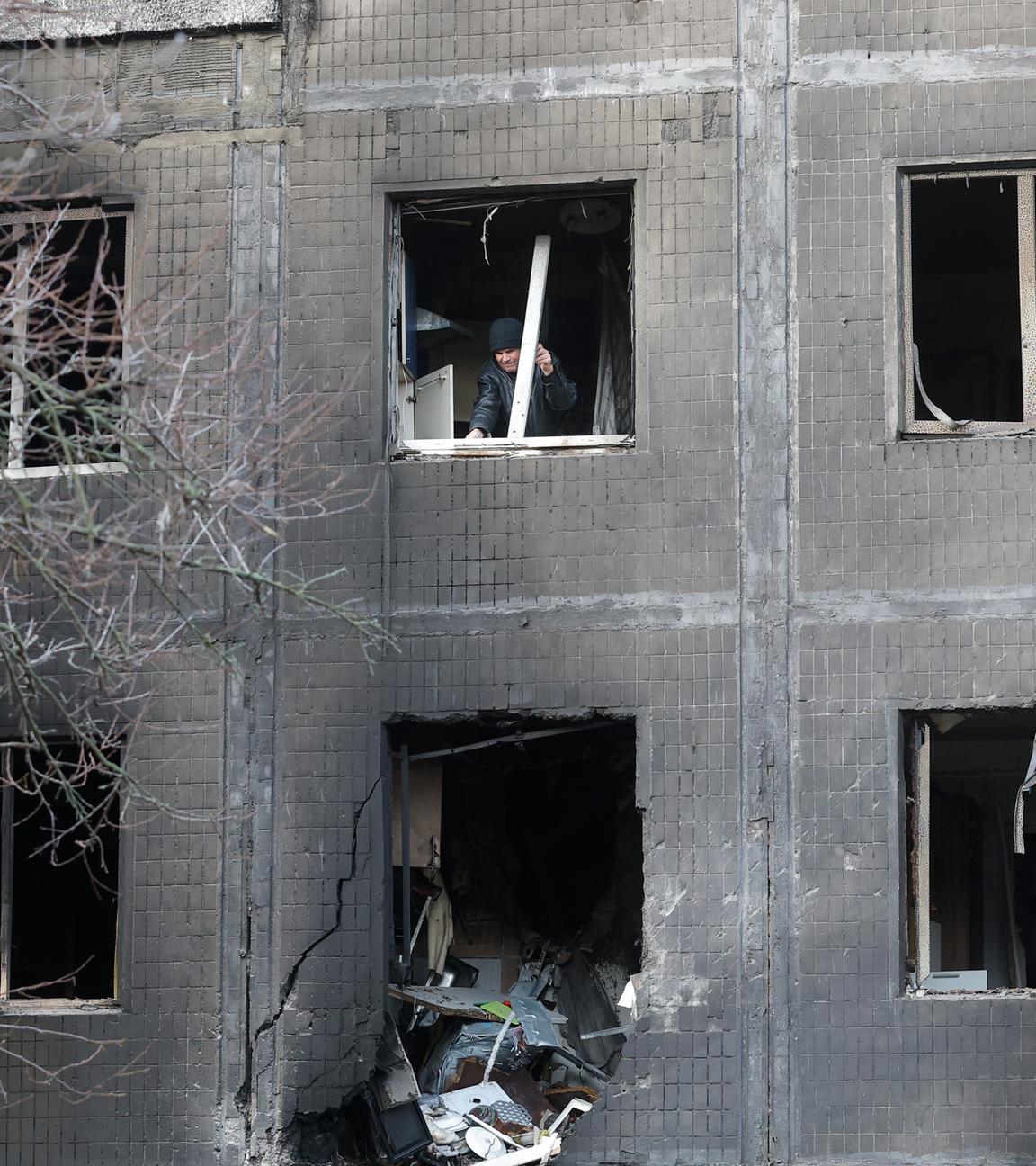 Ein Anwohner räumt Trümmer am Ort eines russischen Angriffs auf ein fünfstöckiges Wohnhaus in Kiew.