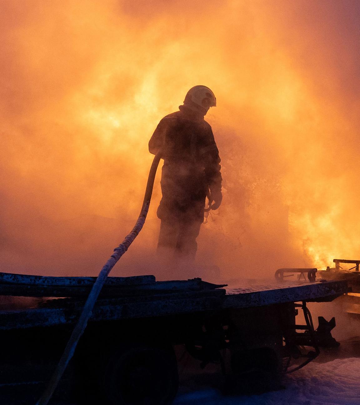 Ukrainische Rettungskräfte löschen am 24. Januar 2026 in Kyjiw einen Brand an der Einschlagstelle nach einem russischen Luftangriff.