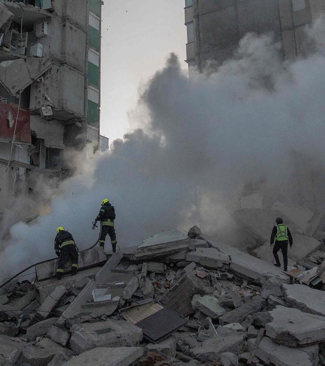 Rettungskräfte arbeiten am 14. Mai 2026 in Kiew an einem teilweise zerstörten Wohngebäude nach russischen Drohnen- und Raketenangriffen im Zuge des russischen Angriffskriegs gegen die Ukraine.