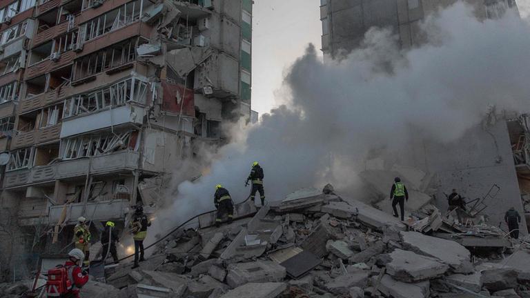 Rettungskräfte arbeiten am 14. Mai 2026 in Kiew an einem teilweise zerstörten Wohngebäude nach russischen Drohnen- und Raketenangriffen im Zuge des russischen Angriffskriegs gegen die Ukraine.
