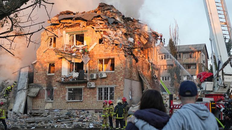 Feuerwehrleute arbeiten an einem brennenden Gebäude nach einem russischen Angriff. 