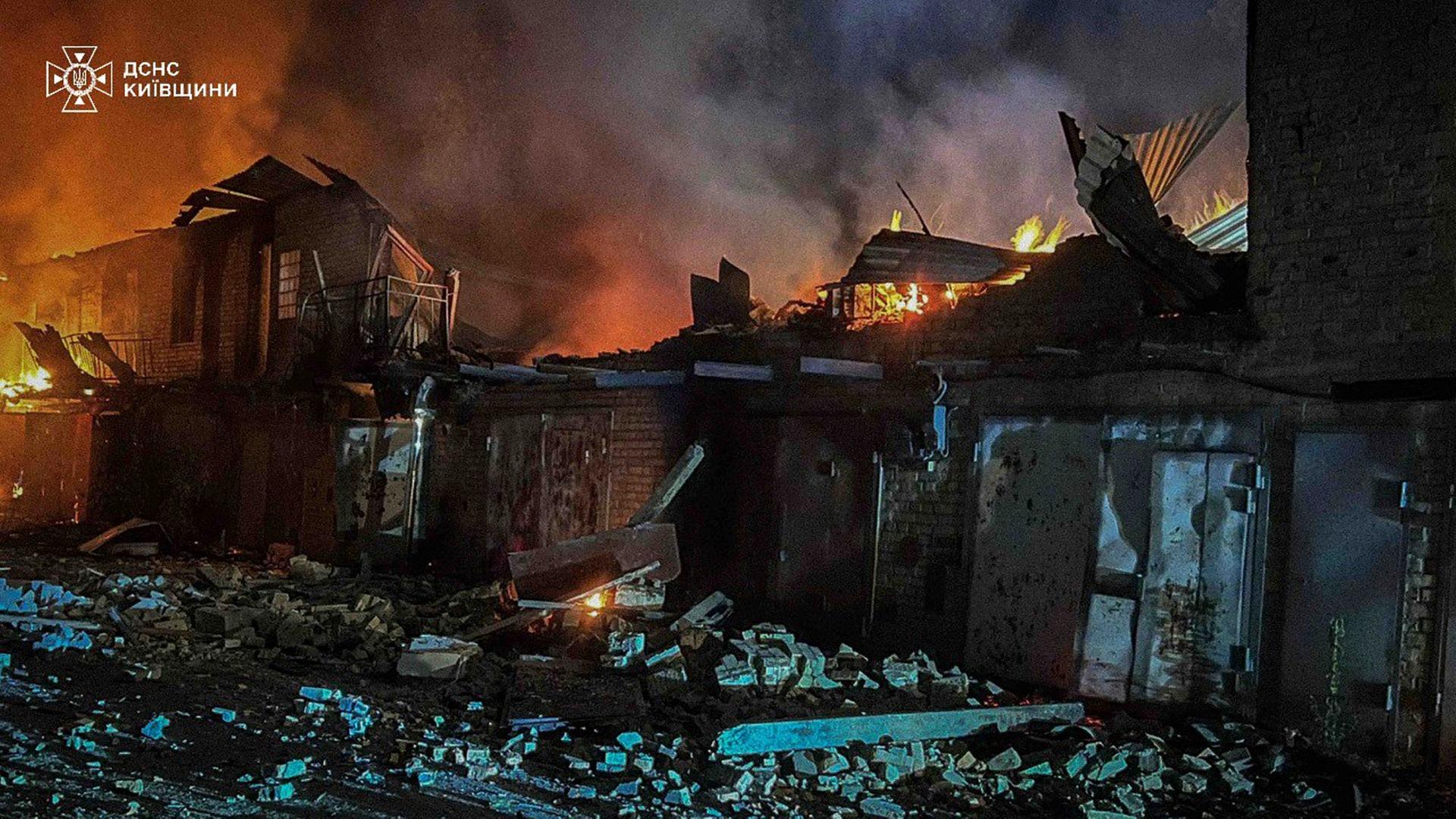 Auf diesem vom ukrainischen Katastrophenschutz zur Verfügung gestellten Foto arbeiten Ersthelfer daran, ein Feuer nach einem russischen Angriff in der Region Kiew zu löschen. 