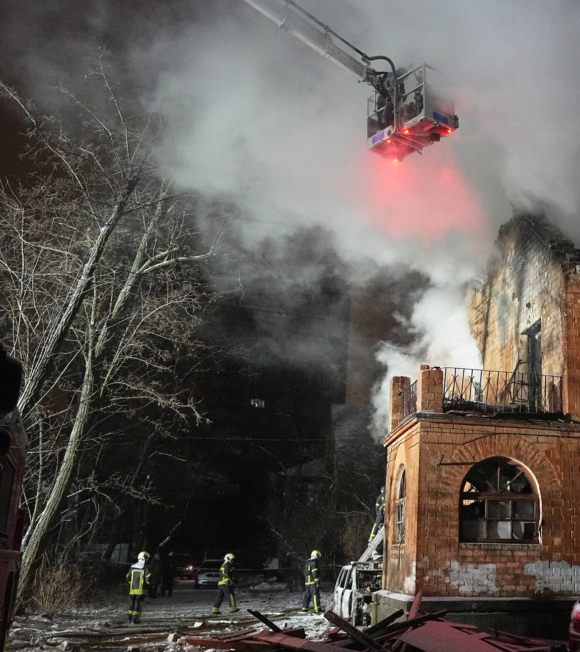 Rettungskräfte löschen ein Feuer in einem Wohnhaus, das durch einen russischen Angriff beschädigt wurde.
