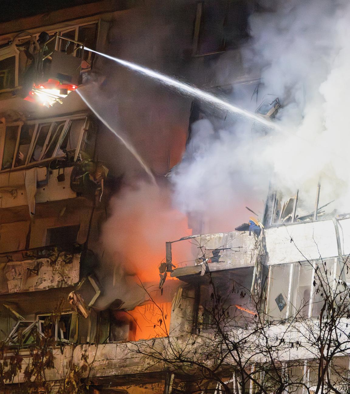 Feuerwehrleute löschen das Feuer nach dem Einschlag einer Drohne in ein mehrstöckiges Wohnhaus während eines nächtlichen russischen Drohnenangriffs in Kiew