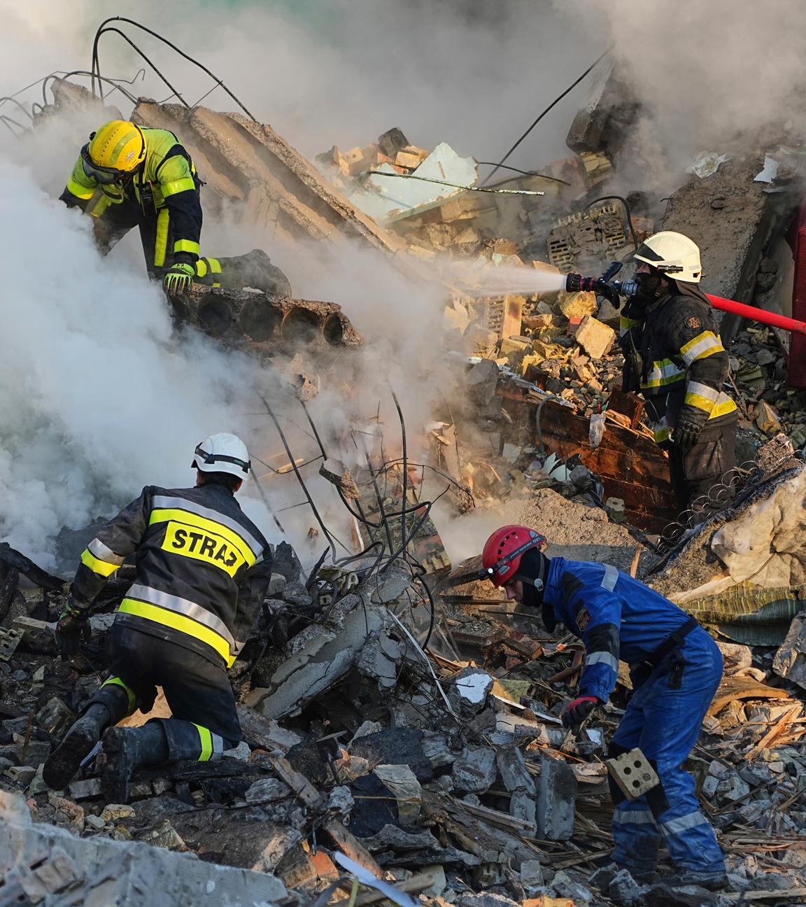 Feuerwehrleute betreten ein Haus, das in Trümmern liegt