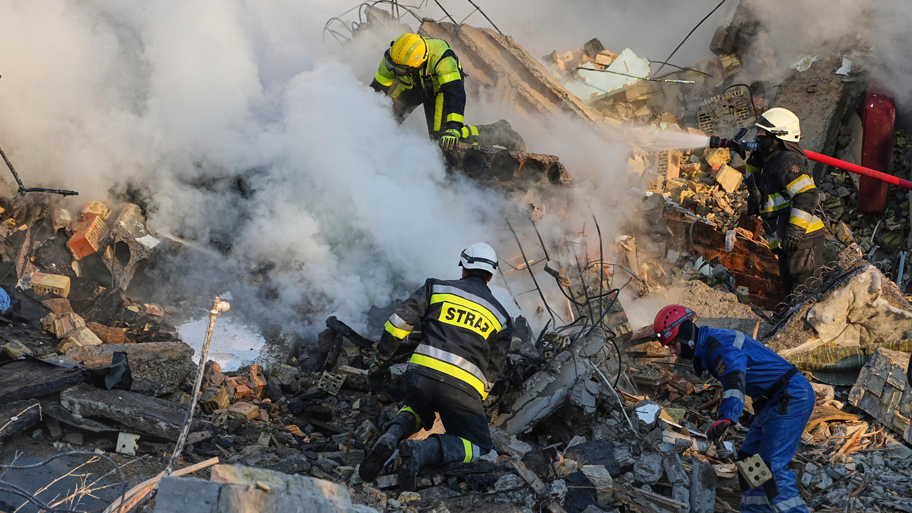 Feuerwehrleute betreten ein Haus, das in Trümmern liegt