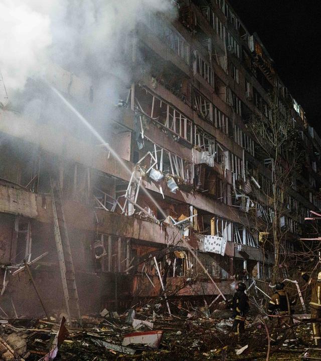  Rettungskräfte löschen einen Brand in einem mehrstöckigen Wohngebäude, das bei einem russischen Raketenangriff auf Kiew in der Ukraine beschädigt worden war.