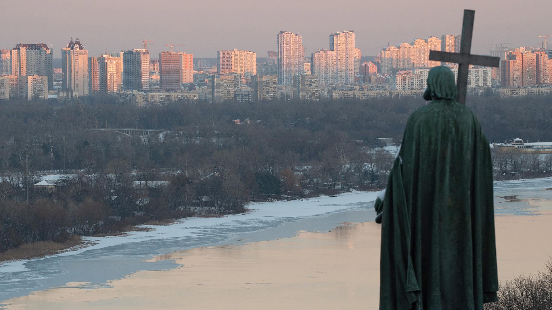 Das Denkmal des Kiewer Großfürsten Wolodymyr des Großen aus dem 19. Jahrhundert überblickt im Winter bei Sonnenuntergang den Fluss Dnipro und das linke Ufer von Kiew.