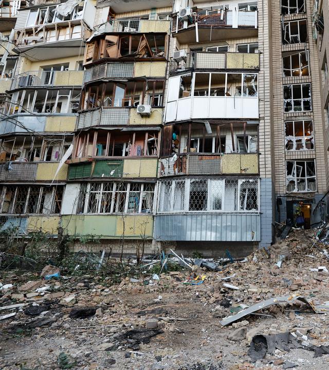 Ein Mann steht vor einem zerstörten Wohnhaus nach den russischen Angriffen auf Kiew am 20. August 2026.