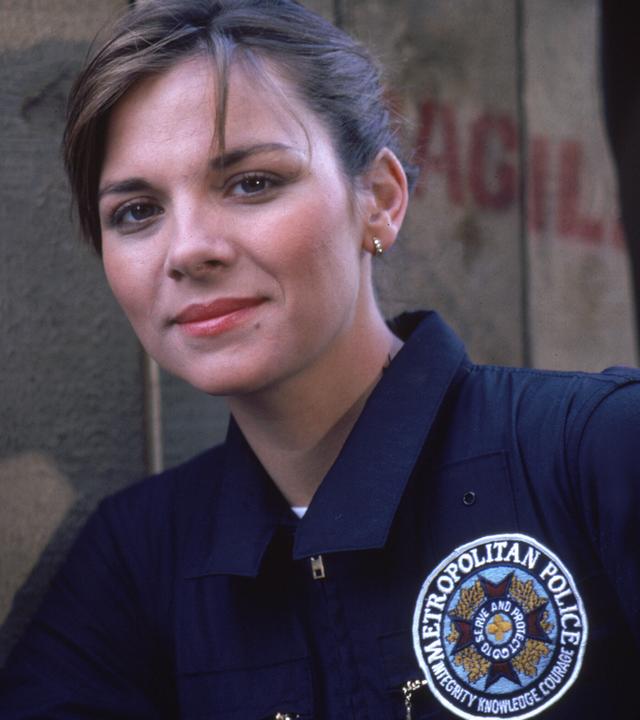 Kim Cattrall als Polizeischülerin in der Serie "Police Academy - Dümmer als die Polizei erlaubt" mit einer Waffe in der Hand.