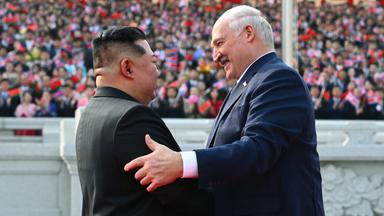 Kim Jong-un und Alexander Lukaschenko in freundschaftlicher Begrüßung vor einer Tribüne mit nordkoreanischem Publikum