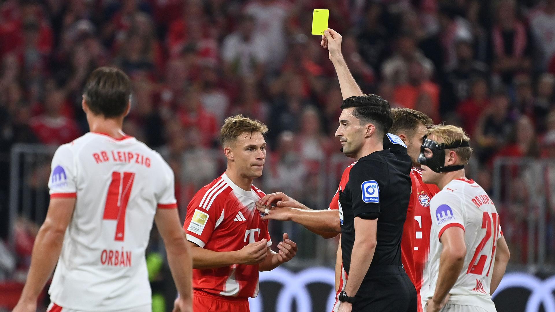 Schiedsrichter Florian BADSTUEBNER zeigt Joshua KIMMICH (Bayern Muenchen) die Gelbe Karte nach Reklamieren nach fragwuerdigem Tor von Leipzig.