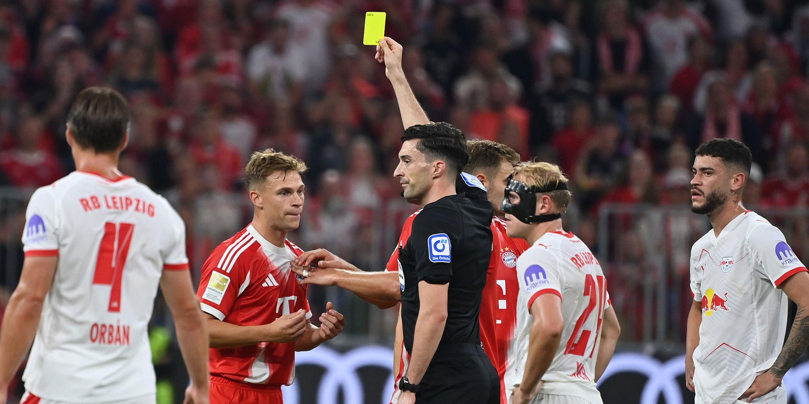 Schiedsrichter Florian BADSTUEBNER zeigt Joshua KIMMICH (Bayern Muenchen) die Gelbe Karte nach Reklamieren nach fragwuerdigem Tor von Leipzig.