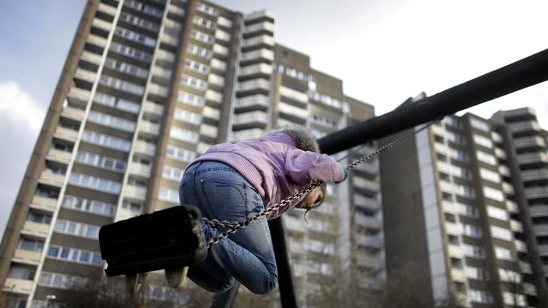 Ein Kind schaukelt am Mittwoch (03.02.2010) vor einem Hochhaus in Meschenich bei Köln.