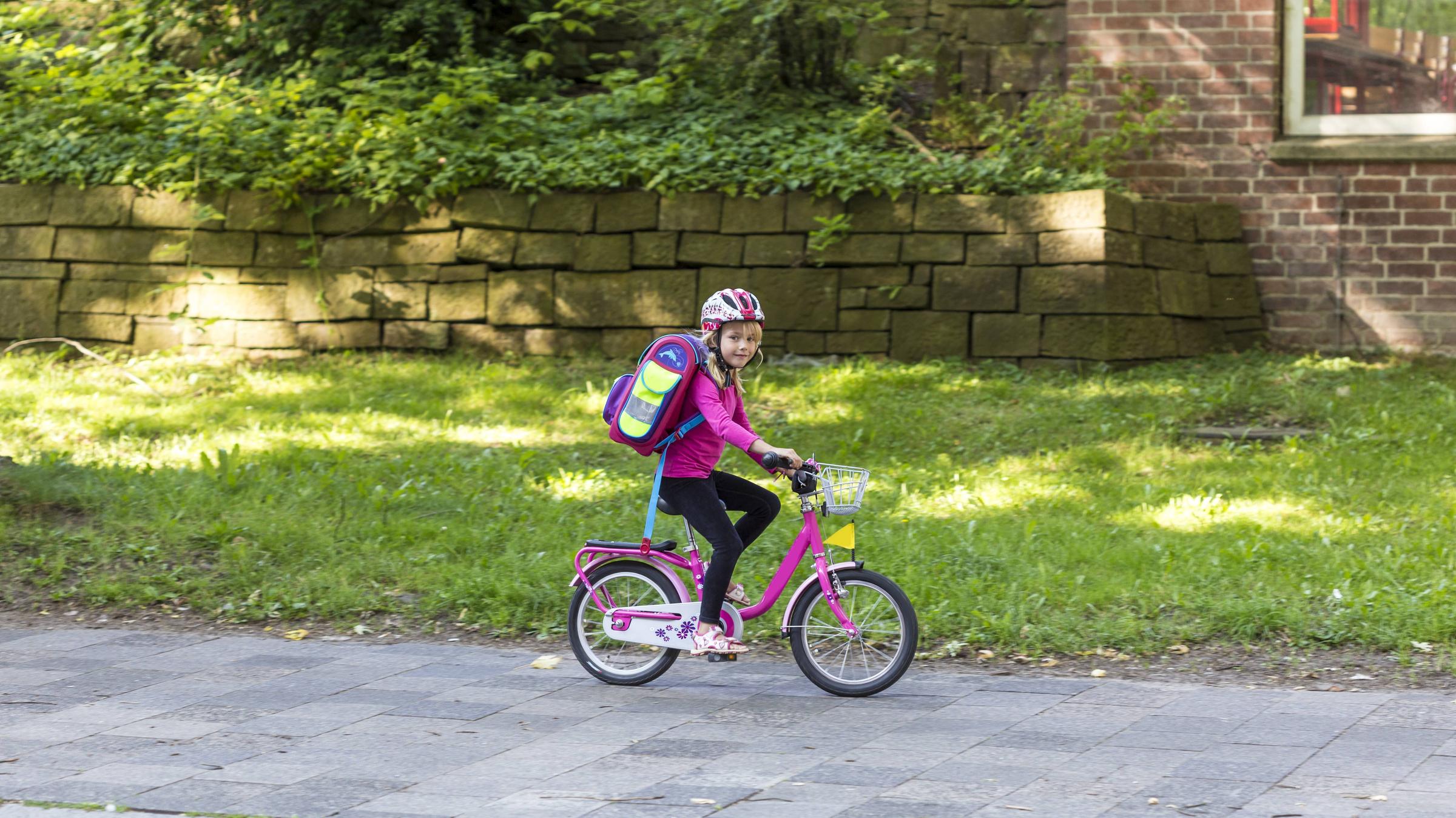 Kind fährt auf dem Gehweg Fahrrad