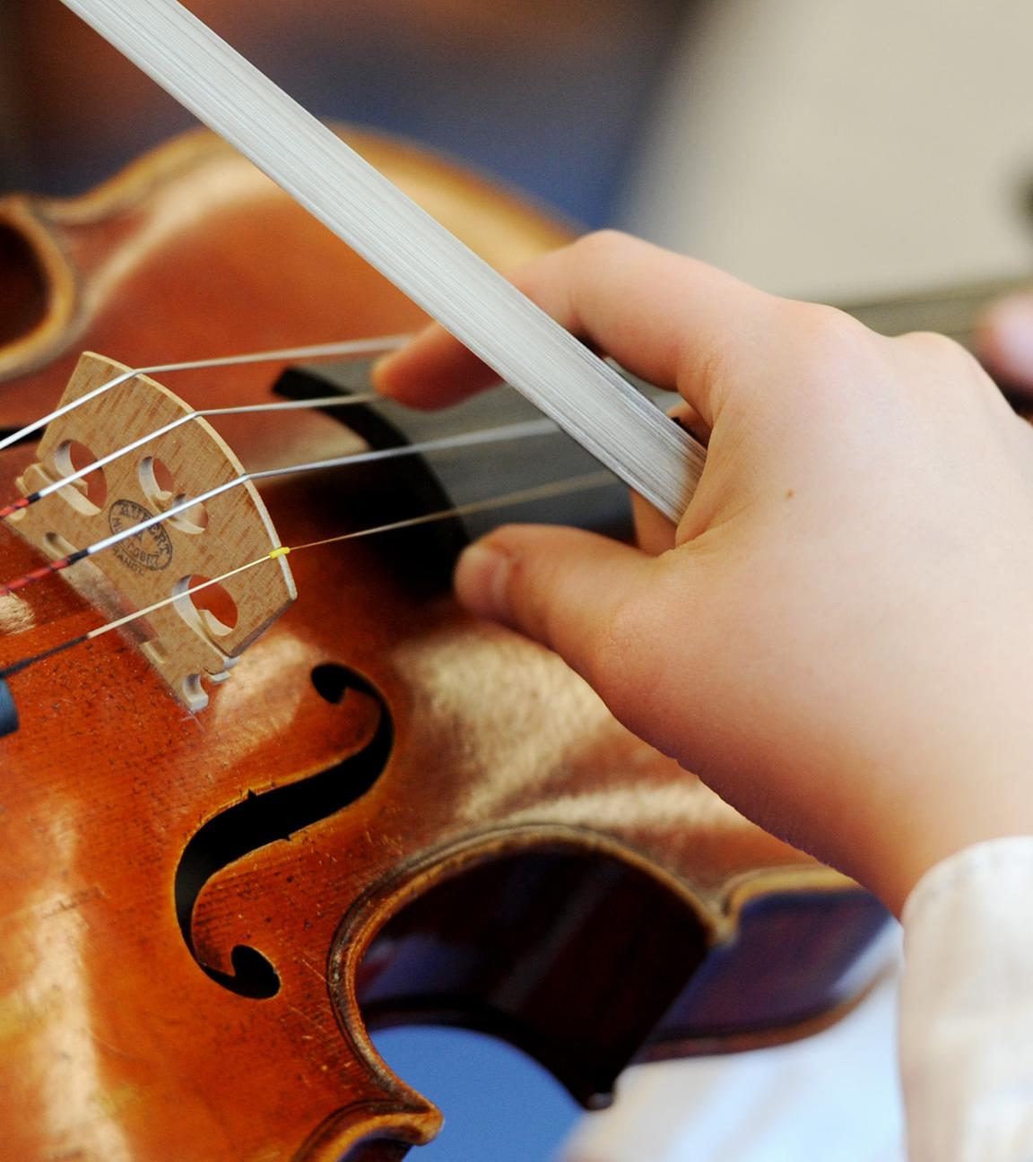 Auf dem Bild sieht man ein Mädchen, was Geige übt.