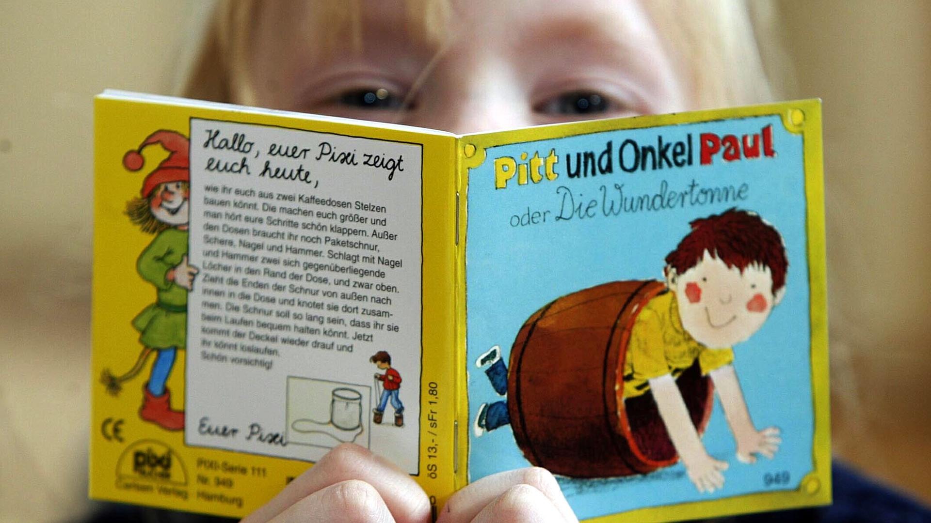 Ein Kind liest im Bilderbuchmuseum auf Burg Wissen in Troisdorf bei Bonn ein Pixi-Buch. Archivbild