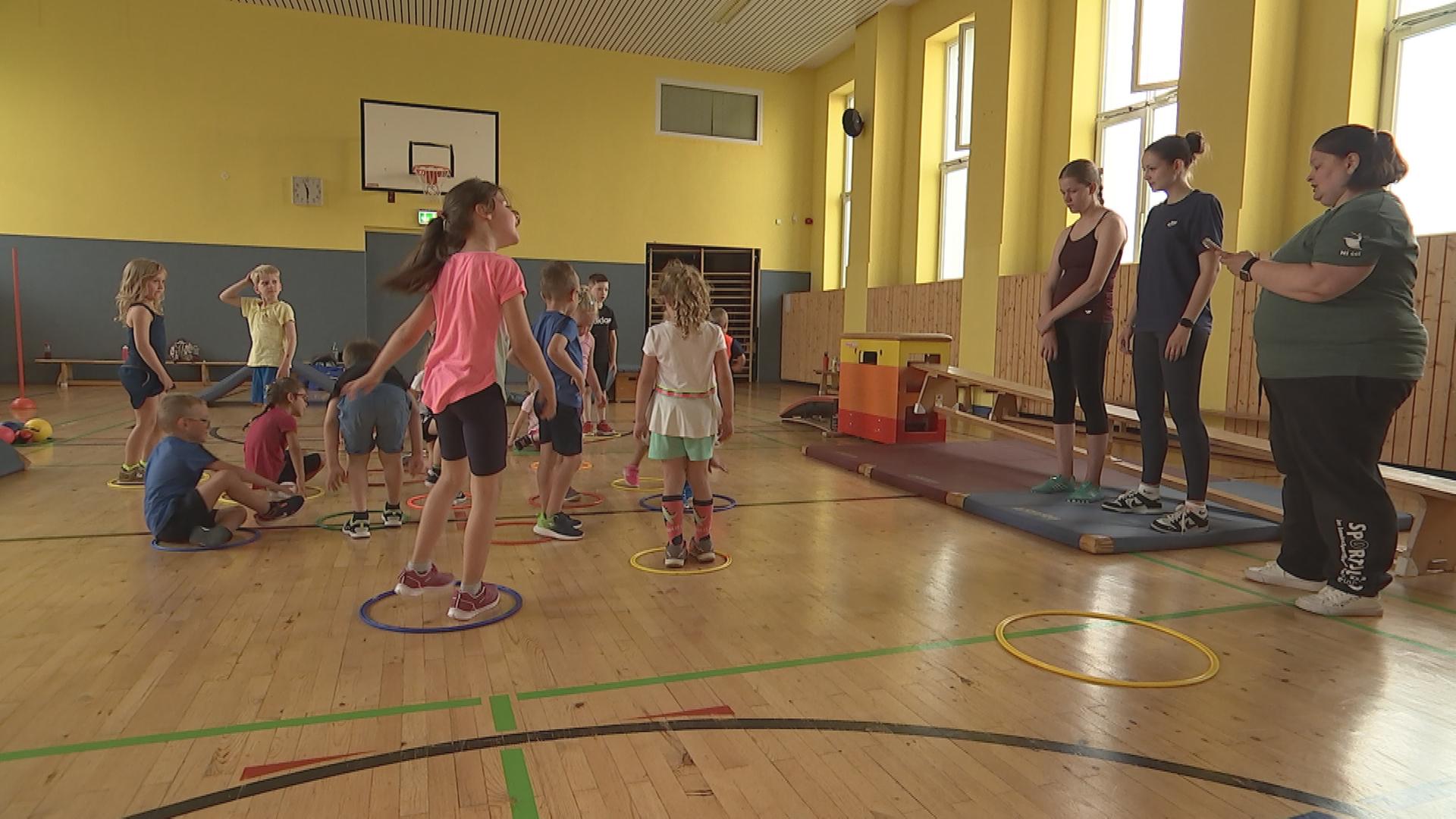 Auf dem Bild sind Kinder beim Sportunterricht zu sehen.