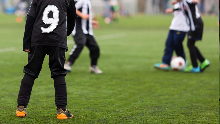 Kinder spielen auf einem Fußballplatz. (Symbolbild)