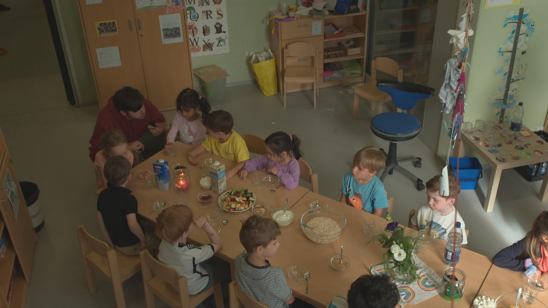 Auf dem Bild sind mehrere Kinder beim Essen in der Kita zu sehen.
