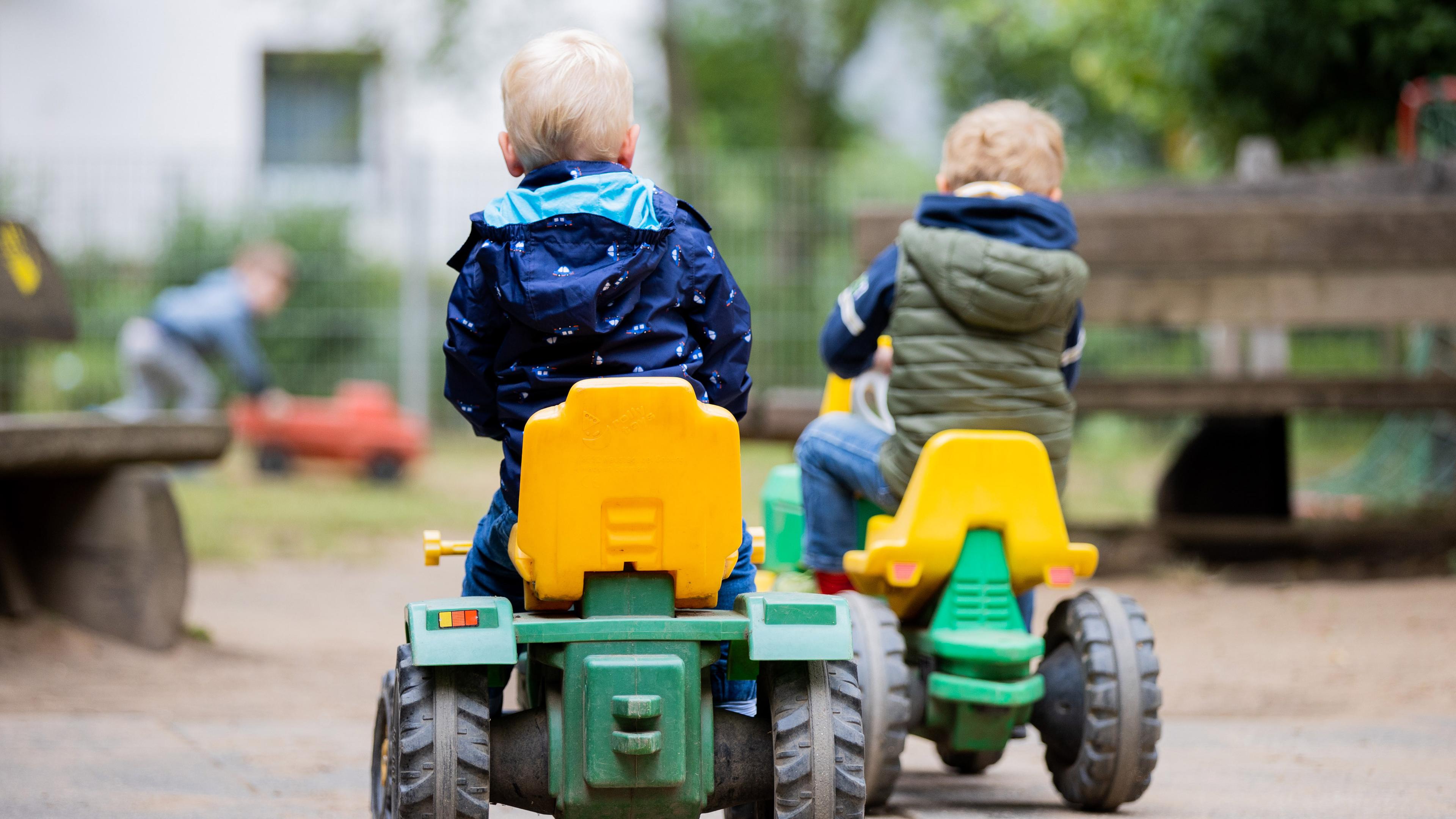 Kinder spielen mit Spielzeugautos auf dem Gelände einer Kita in Baden-Württemberg.