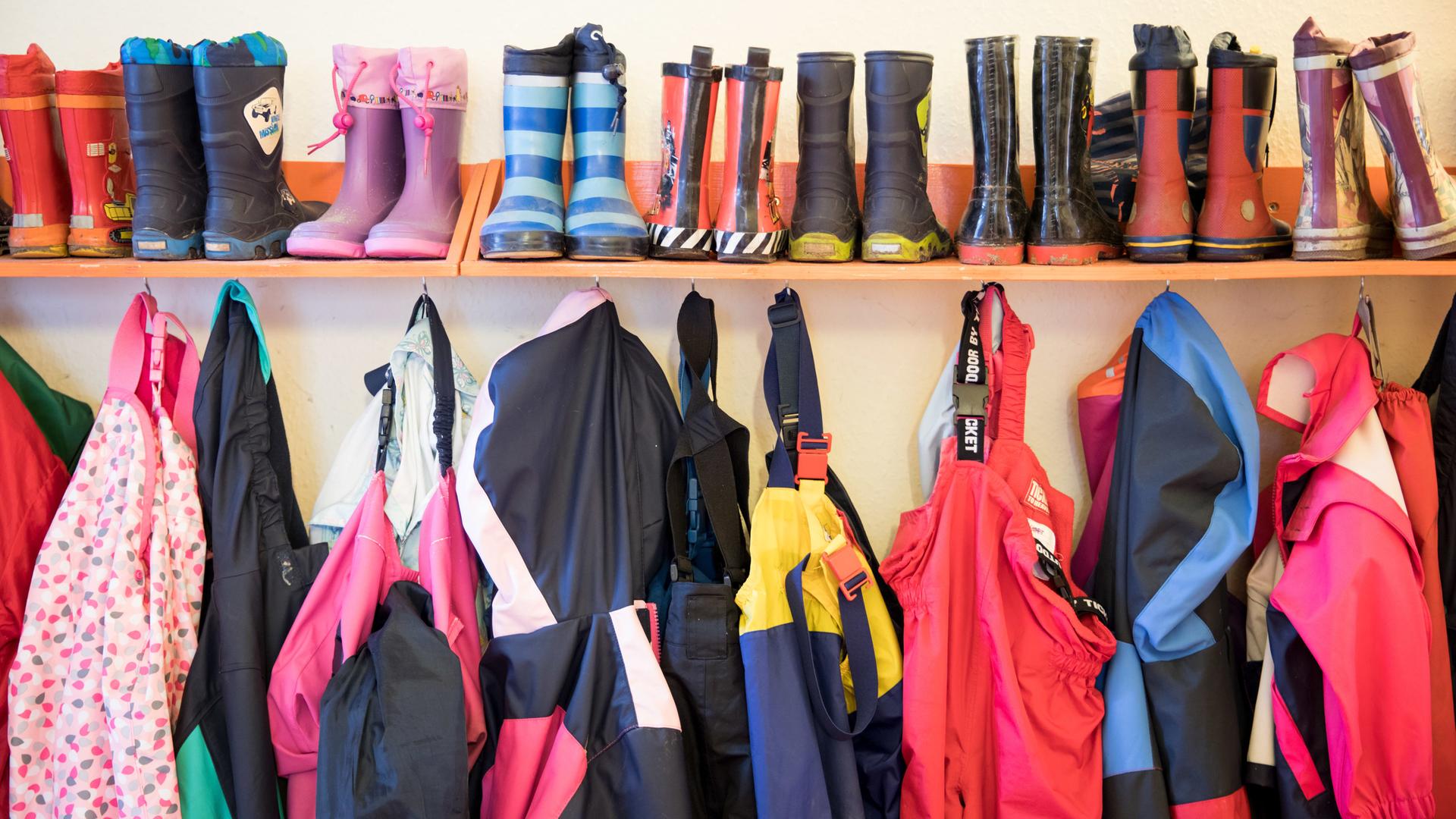 Gummistiefel und Regenhosen von Kindern eines Kita in Schleswig-Holstein hängen an einem Regal am 05.05.2020  