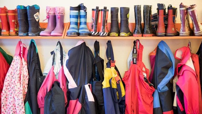 Gummistiefel und Regenhosen von Kindern eines Kita in Schleswig-Holstein hängen an einem Regal am 05.05.2020  