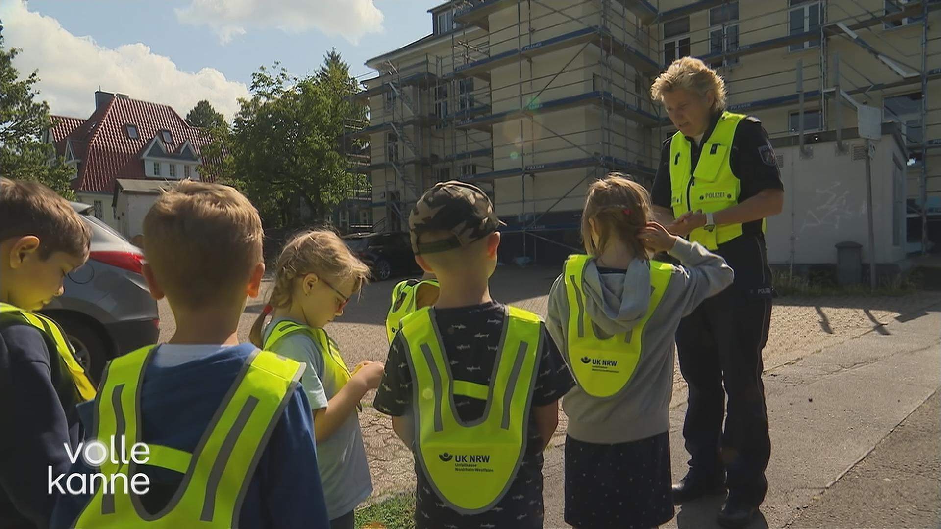Vorschulkinder in gelben Westen üben den Schulweg