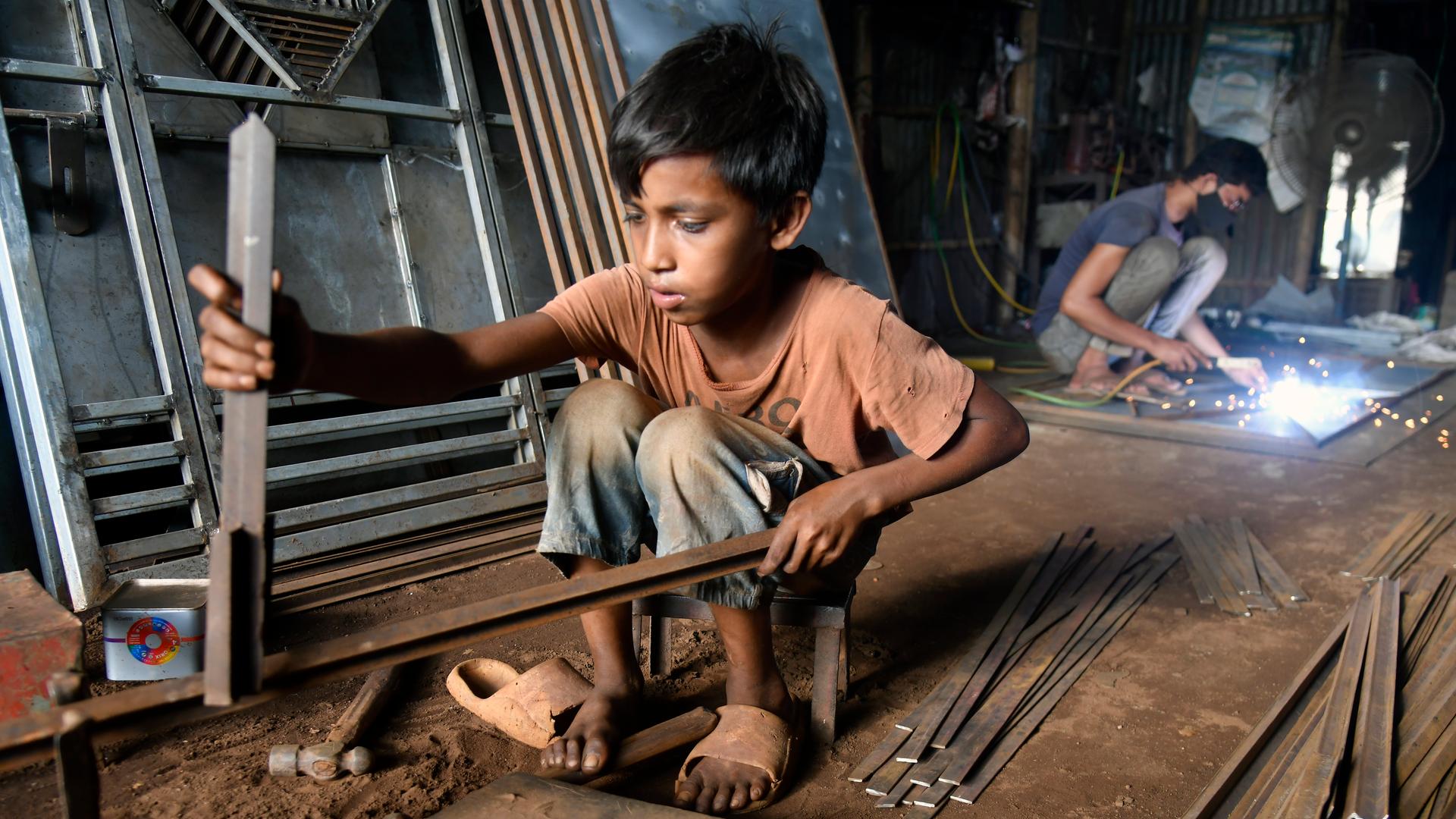Ein Junge arbeitet in einer Werkstatt in Bangladesch.