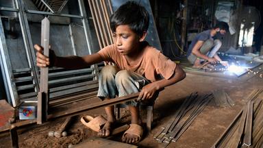 Ein Junge arbeitet in einer Werkstatt in Bangladesch.