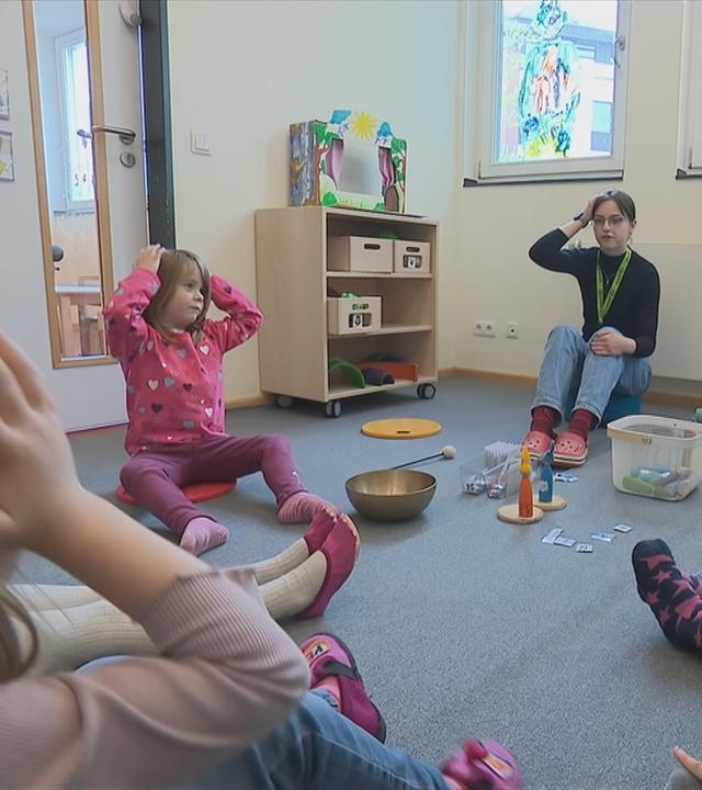 Freiwillige macht Sitzkreis mit den Kindergartenkindern.