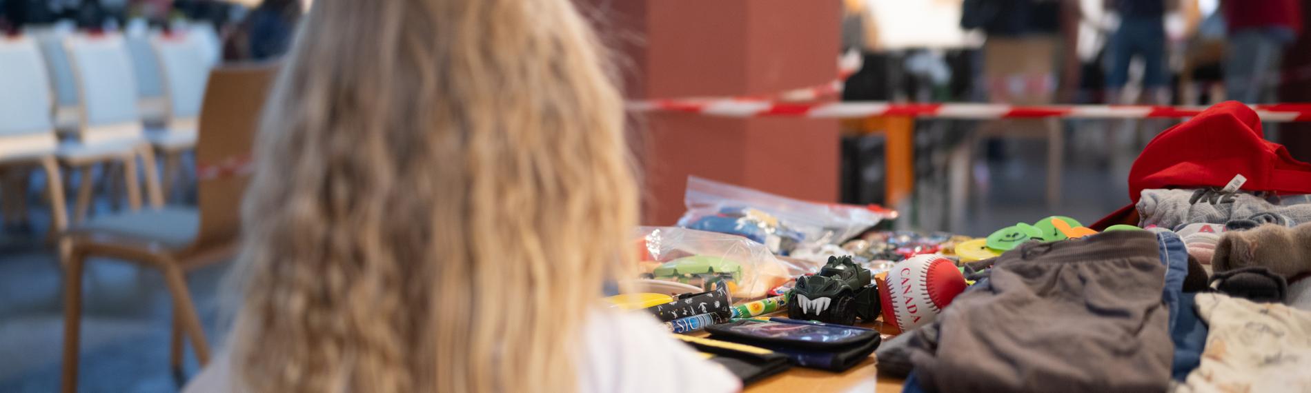 Kind Emilya steht während der Ausgabezeit in einer «Laib und Seele»-Ausgabestelle der Berliner Tafel in der evangelischen Paulus-Kirchengemeindean einem Tisch mit Spielzeug.