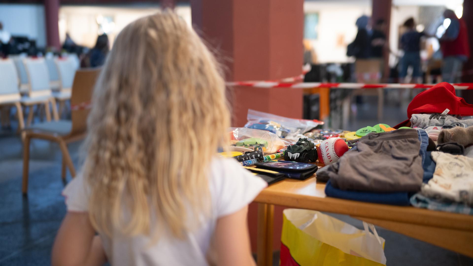 Kind Emilya steht während der Ausgabezeit in einer «Laib und Seele»-Ausgabestelle der Berliner Tafel in der evangelischen Paulus-Kirchengemeindean einem Tisch mit Spielzeug.