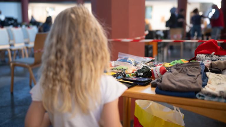 Kind Emilya steht während der Ausgabezeit in einer «Laib und Seele»-Ausgabestelle der Berliner Tafel in der evangelischen Paulus-Kirchengemeindean einem Tisch mit Spielzeug.