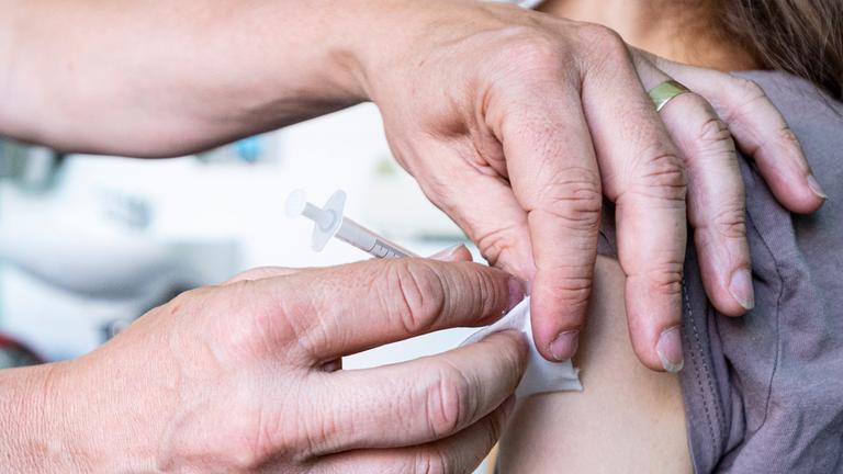 Ein Kind bekommt eine Impfspritze in den Oberam.