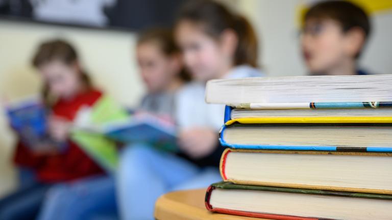 Buchstapel vor lesenden Kindern