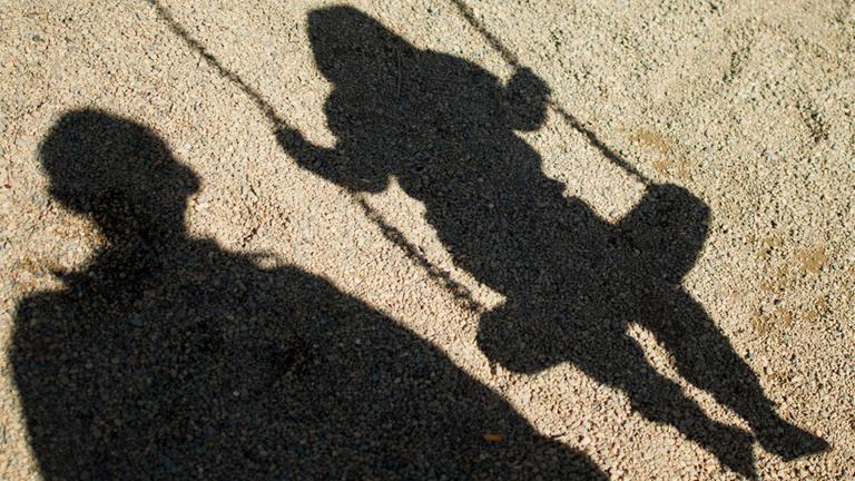 Archiv: Schatten von einem Mann und einem schaukelnden Kind, aufgenommen am 27.08.2014