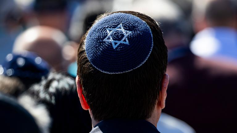 Ein Besucher einer Gedenkveranstaltung trägt eine Kippa mit Davidstern. (Archiv)