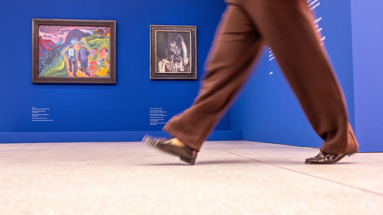 23.09.2025, Nordrhein-Westfalen, Münster: Im LWL Museum für Kunst und Kultur geht eine Frau vor einem Gemälde von Ernst Ludwig Kirchner und einem Gemälde von Pablo Picasso.