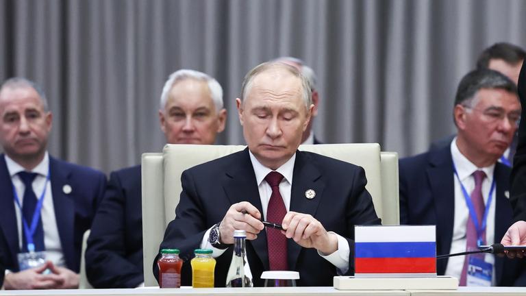 Kirgistan, Bischkek: Der russische Präsident Wladimir Putin (M) unterzeichnet letzte Dokumente während einer regulären Sitzung des Kollektiven Sicherheitsrats der Organisation des Vertrags über kollektive Sicherheit (OVKS) in der Staatsresidenz Yntymak Ordo.