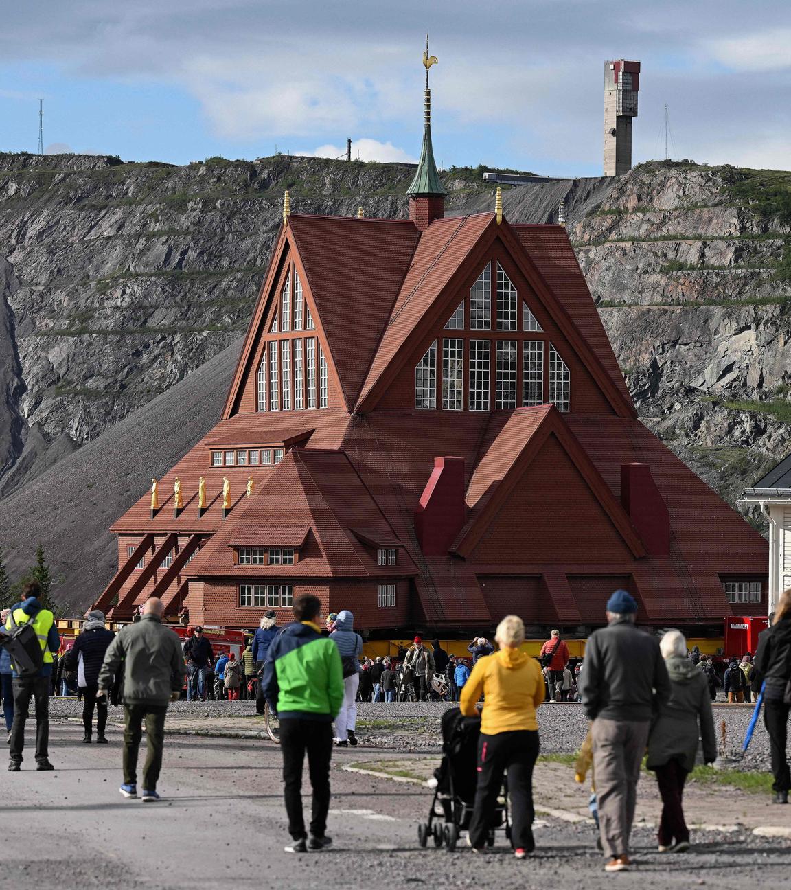 Schweden, Kiruna: Die Kirche aus Holz wird transportiert, während viele Menschen zuschauen.