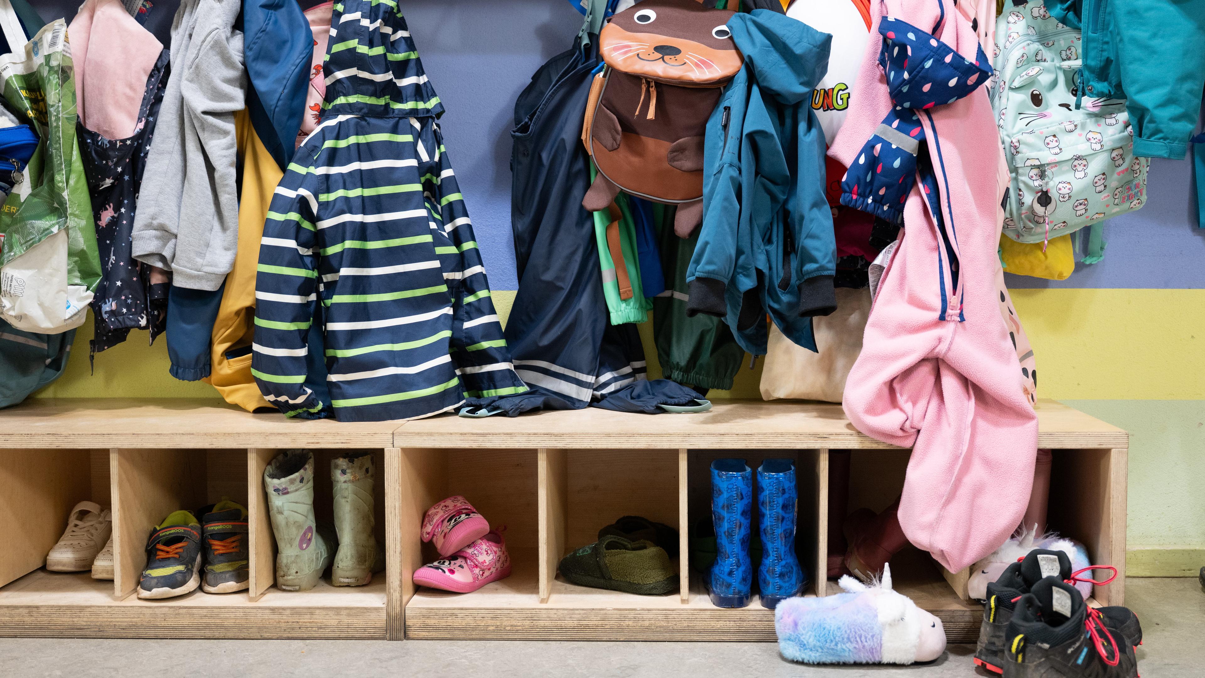 Jacken und Schuhe befinden sich in einer Garderobe in einer Kita in Dresden. 