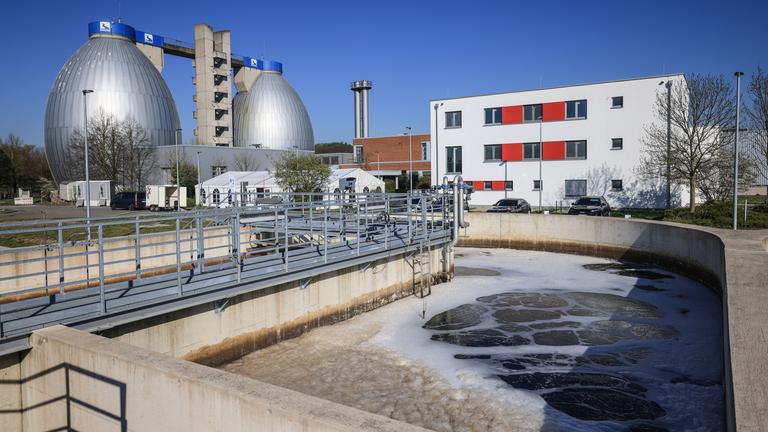 Kläranlage mit Faultürmen im Hintergrund, blauer Himmel