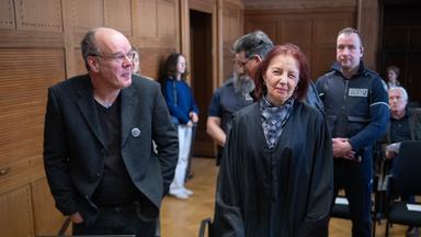 Der Kläger Marianus Krall (l) steht mit seiner Anwältin (vorne r) im Verhandlungssaal des Verwaltungsgerichts. 