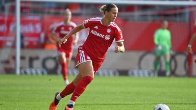 Fussballerin Klara Bühl setzt im roten Bayern-München-Trikot zu einem Dribbling an. 