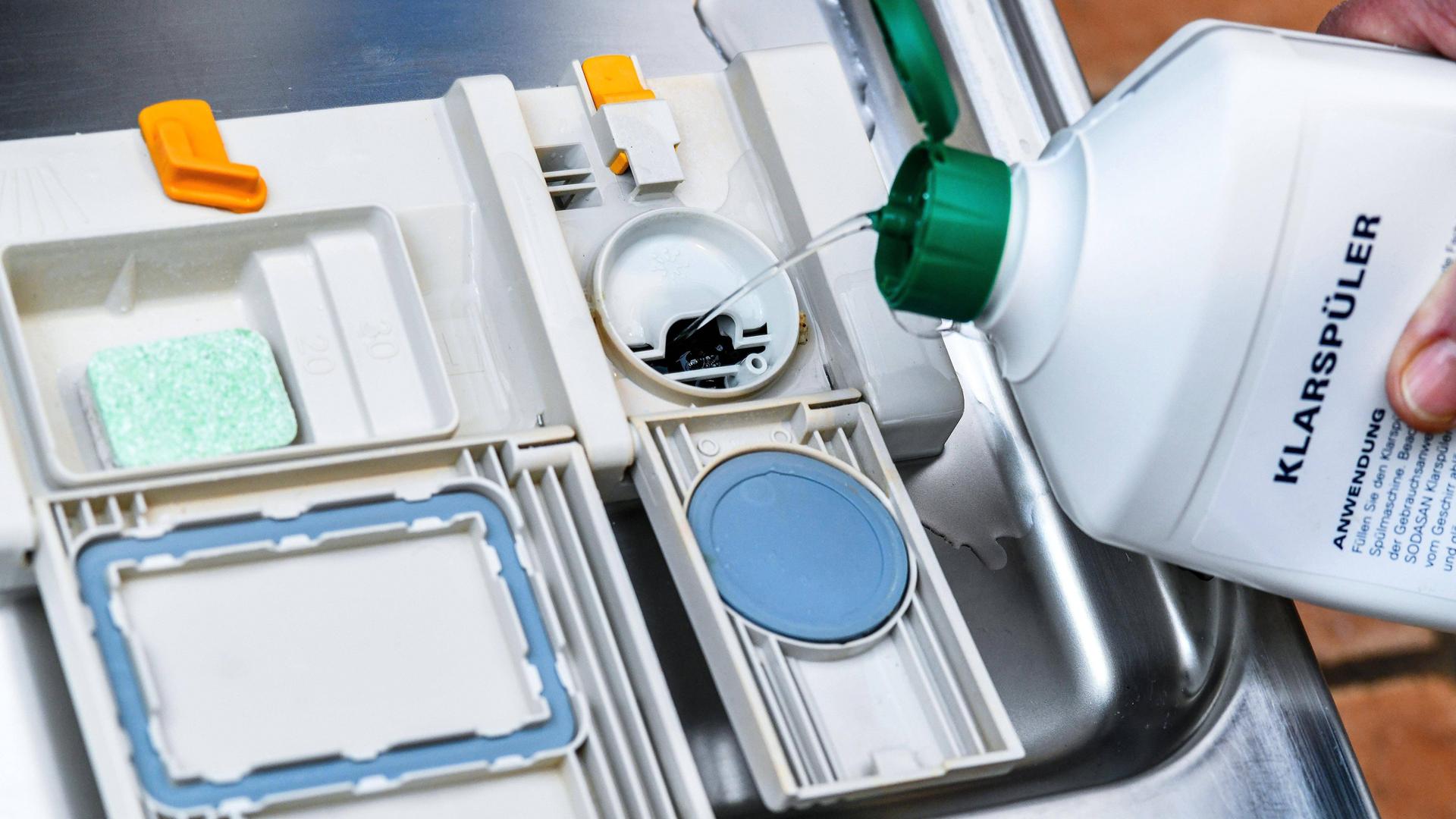 Klarspüler wird in das zugehörige Fach der Spülmaschine gekippt. 
