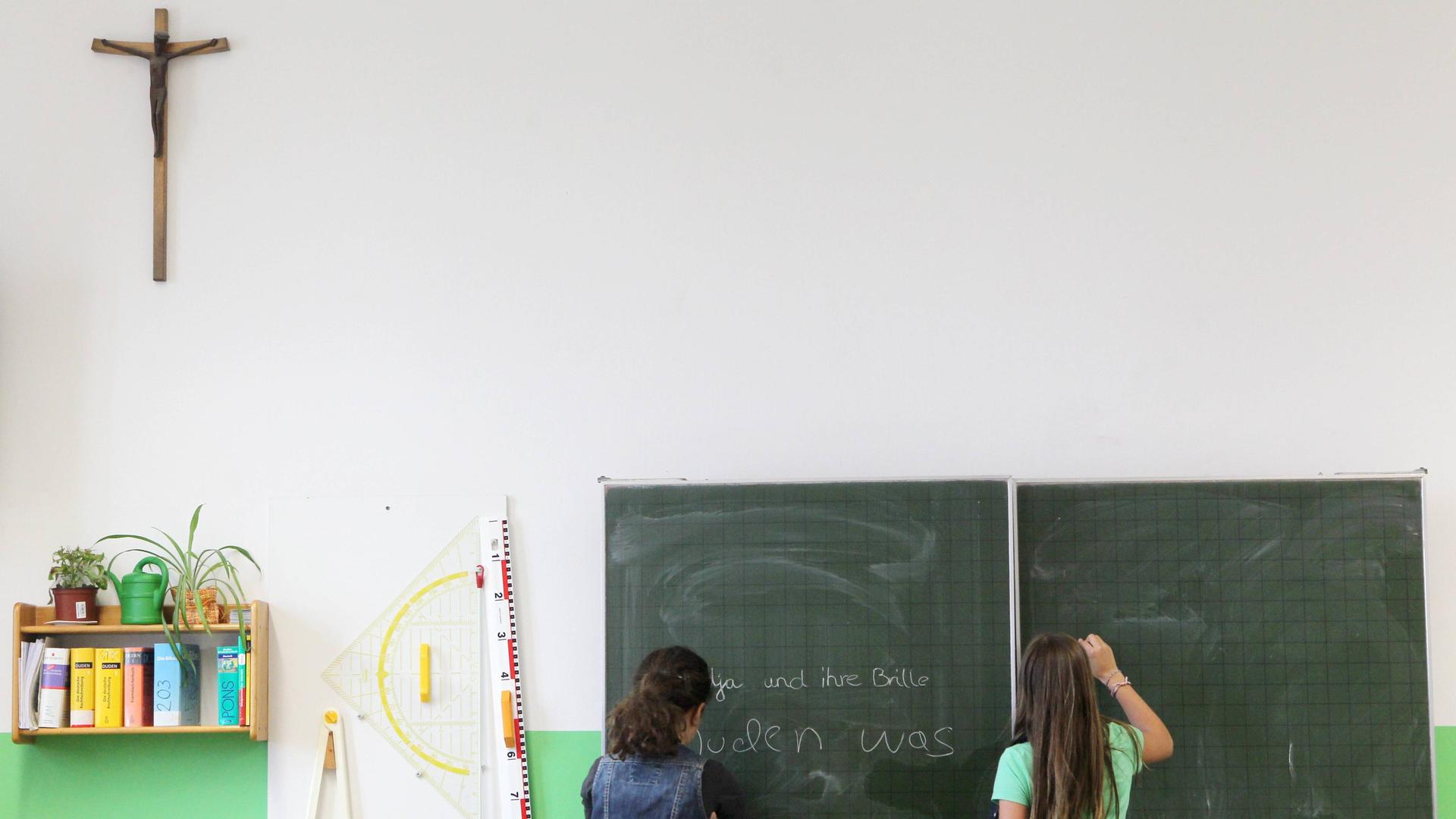 Ein Kruzifix hängt im Klassenzimmer. Das Bild soll Unterricht im Fach Religion symbolisieren.